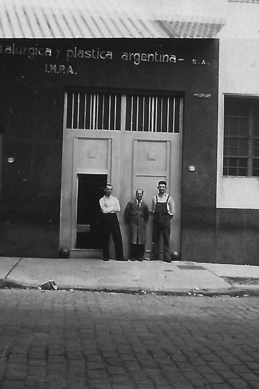 “El mudo” y dos de los hermanos Hubeli, trabajadores de IMPA de la primera etapa en la puerta de la fábrica. Foto: Archivo Familia Hubeli